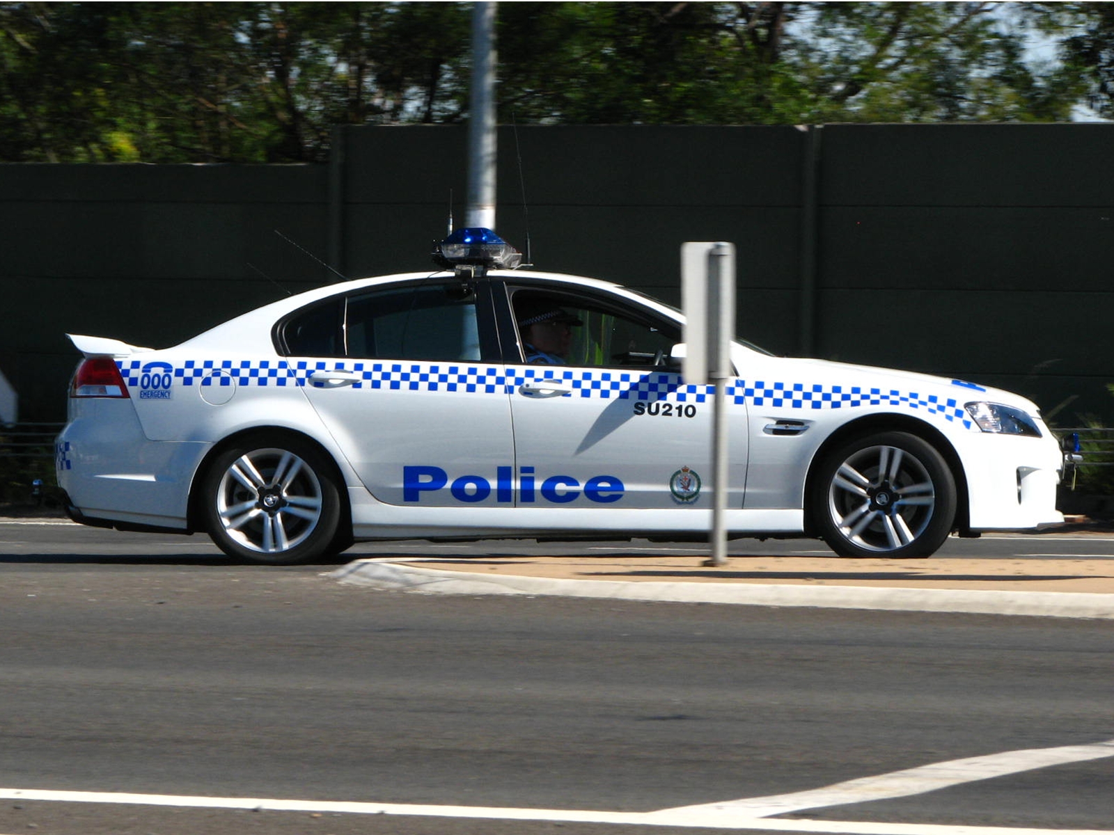 police car parked next to an intersection sign