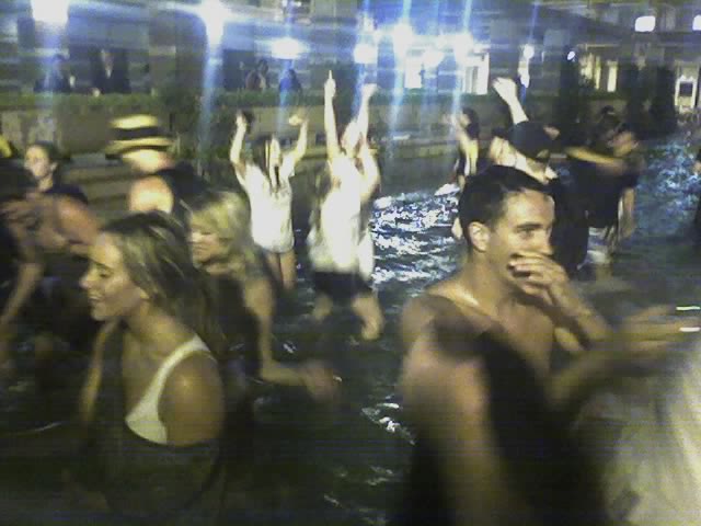 people standing and playing in water with hands up