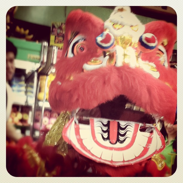 red chinese masks with gold accents displayed at a store