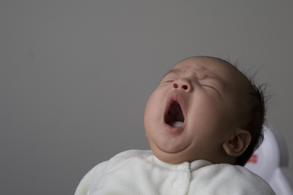 a baby with its mouth open with one eye closed