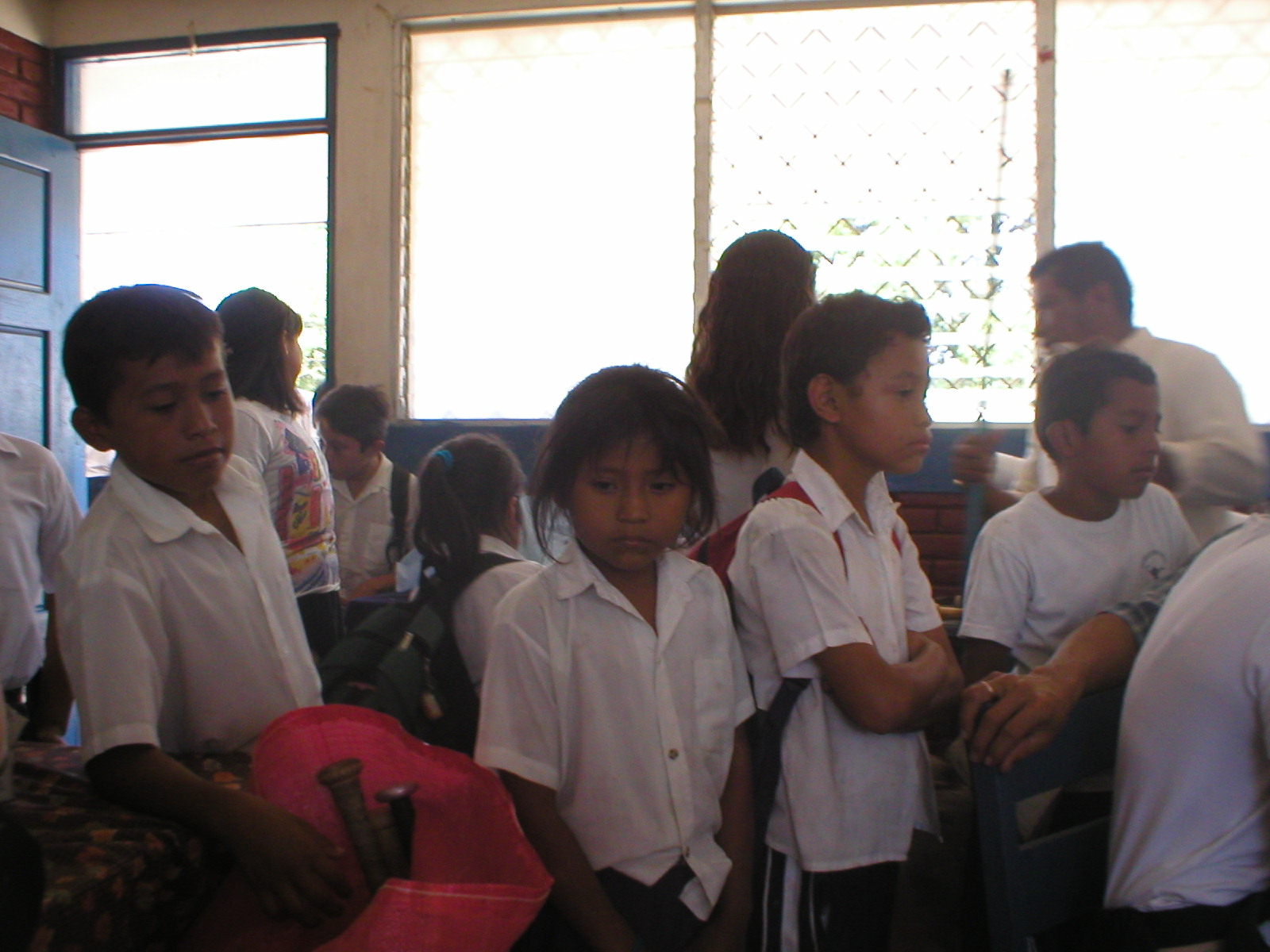 a group of school children standing and sitting together in a line