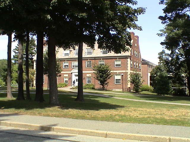 a tall red brick building sitting next to a lush green park