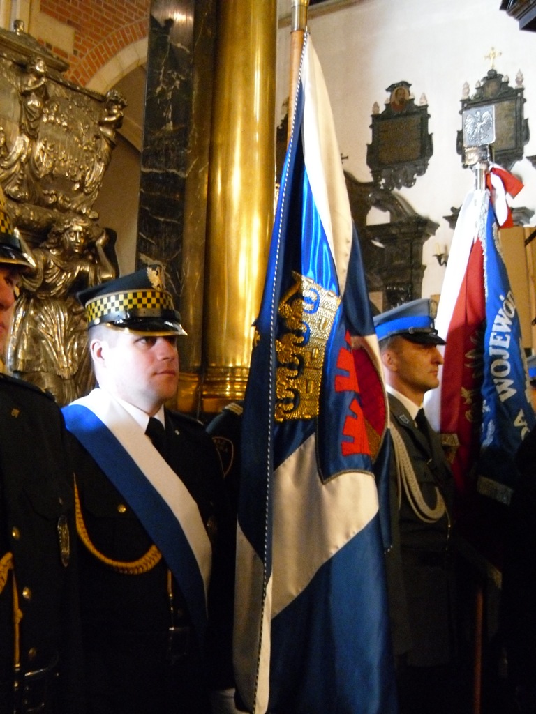 two officers in dress blue uniform standing next to flags