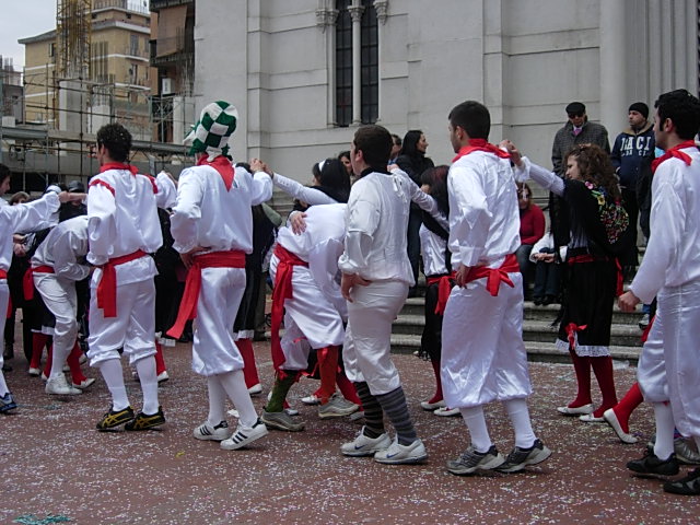 group of men with white suits and red ties dancing