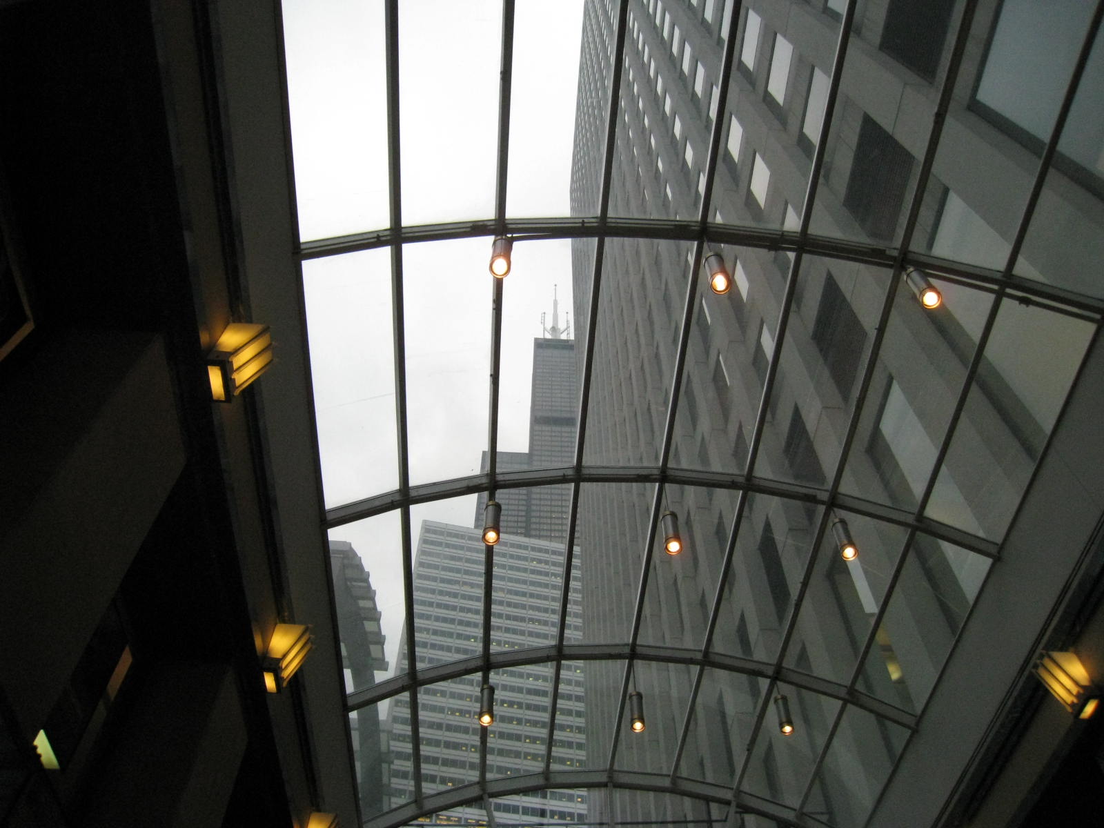 looking up through a glass covered ceiling into a tall building