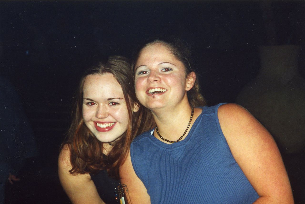 two girls are smiling at the camera and posing
