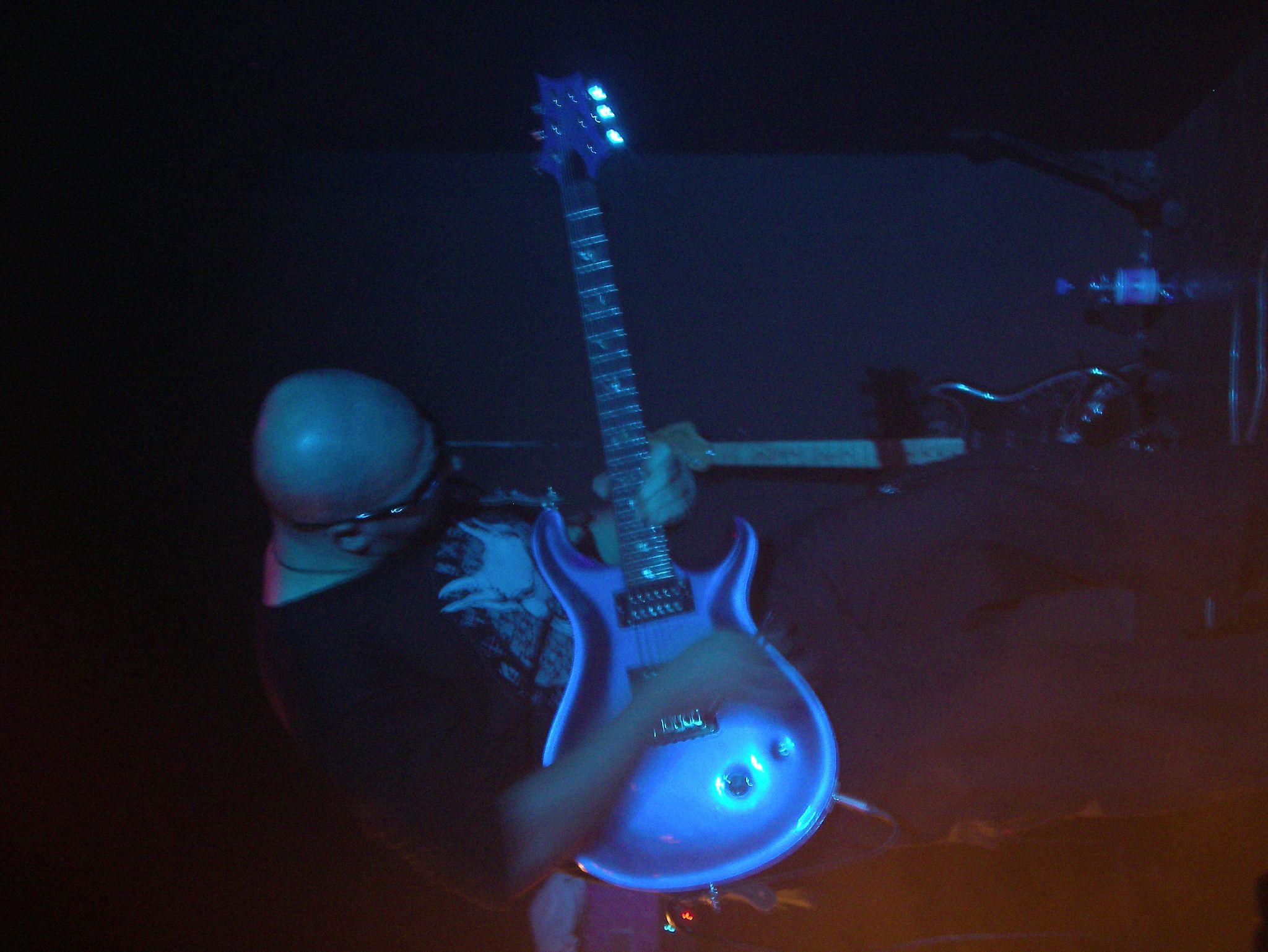 a person in black and white holding a blue guitar