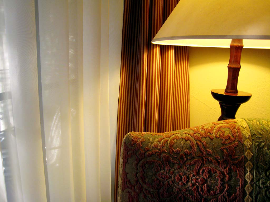a lamp sitting on top of a chair next to a window