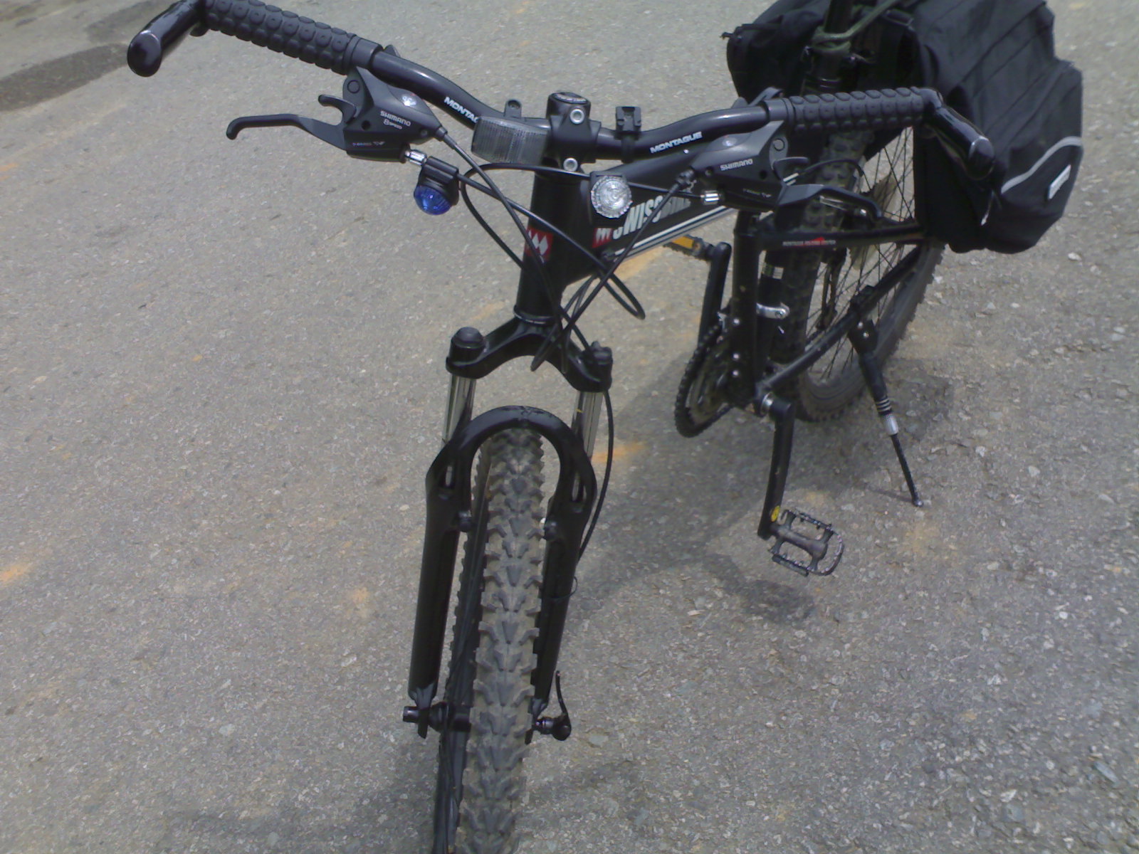 the rear and back view of a bike with bags strapped on it