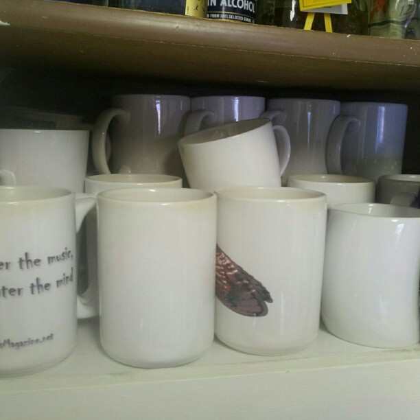 cups of coffee sit on a shelf at a restaurant