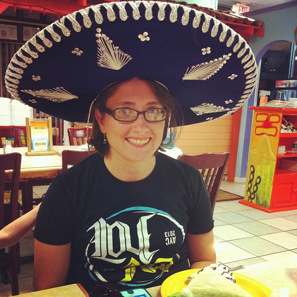 woman with mexican hat on eating at table