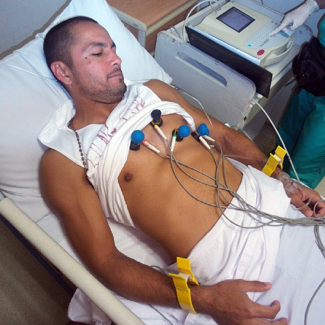 a shirtless man lying in a hospital bed
