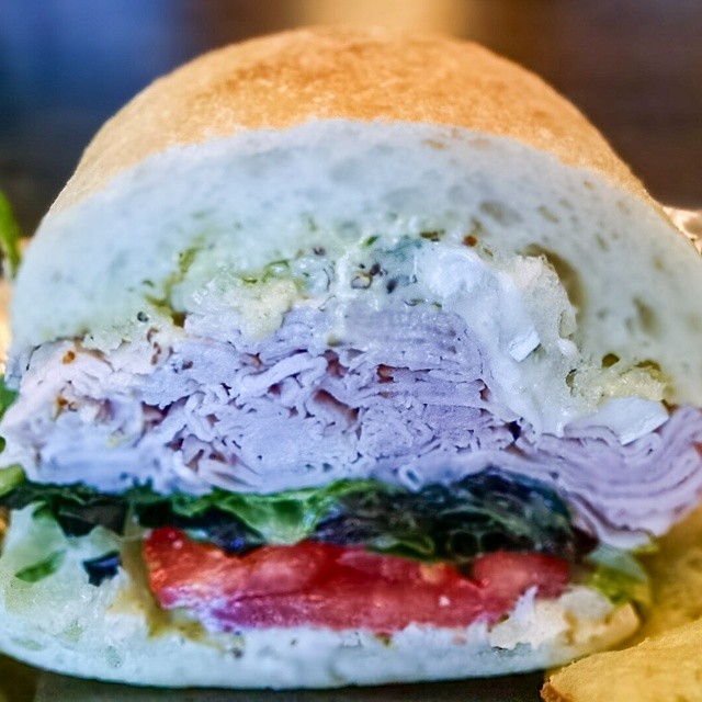 a closeup of a large sandwich with lettuce and tomato slices