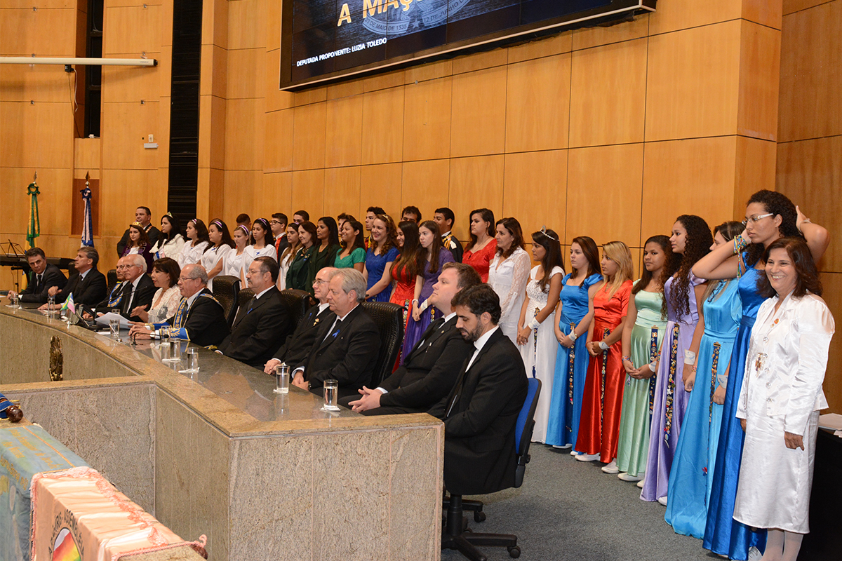 people in suits and ties sit on the stage in front of other people