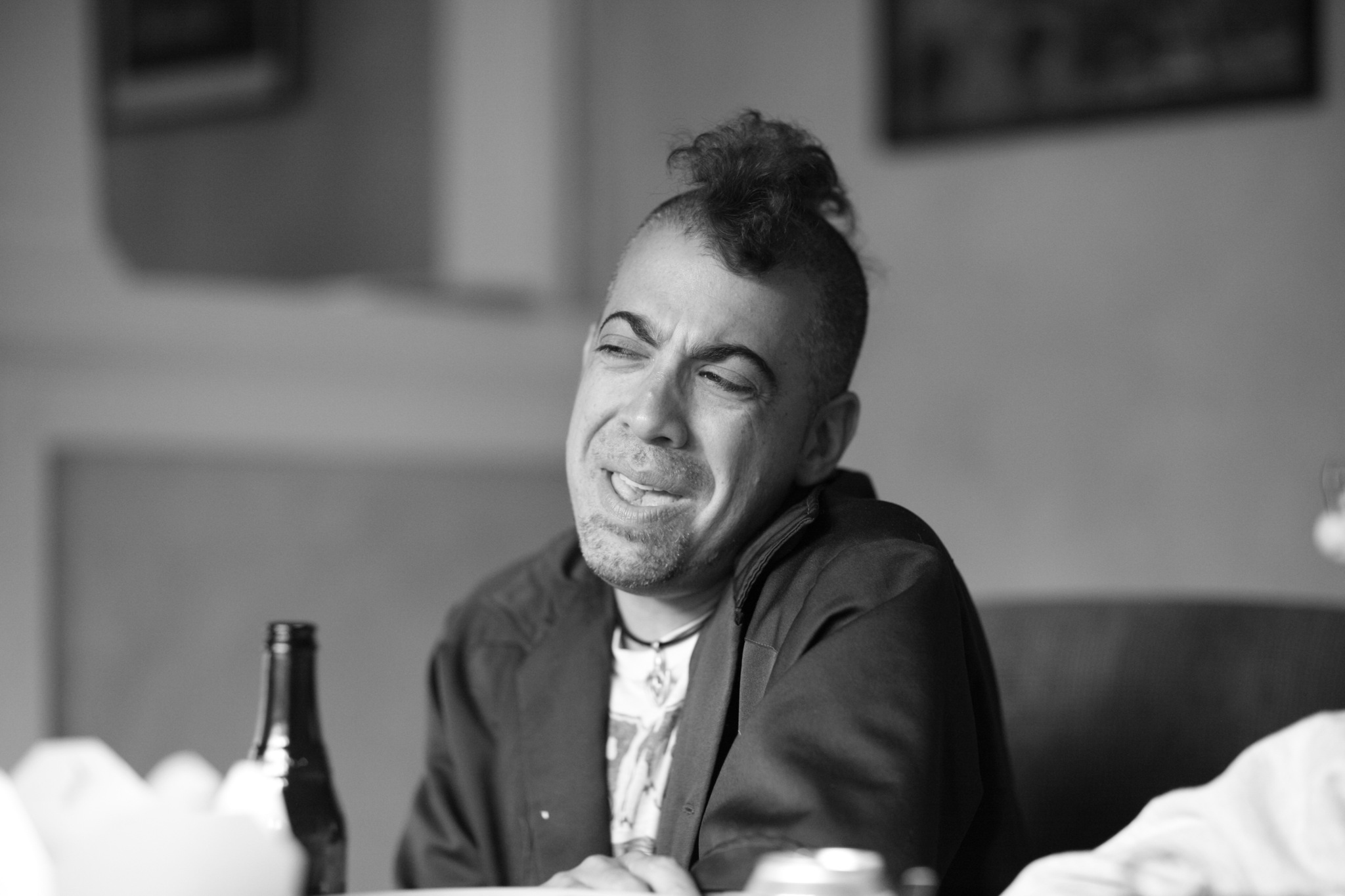 a man with his eyes closed while sitting down in a restaurant