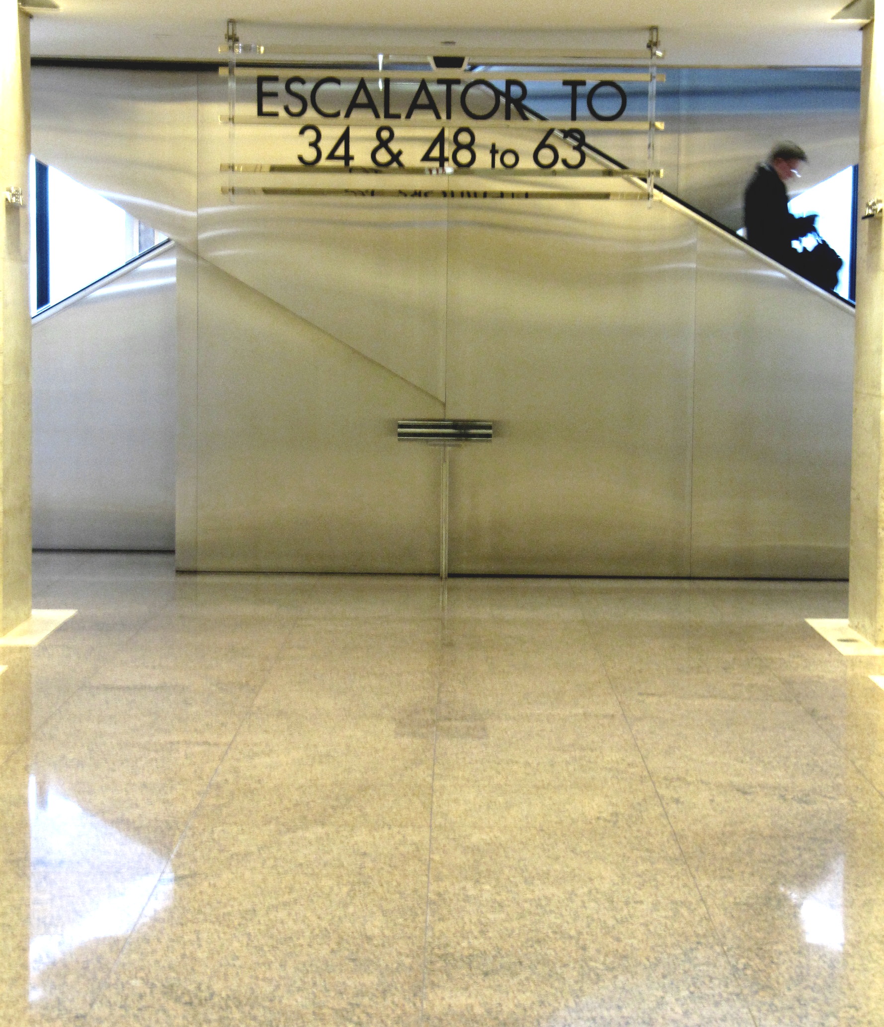 a couple of people walking down an escalator