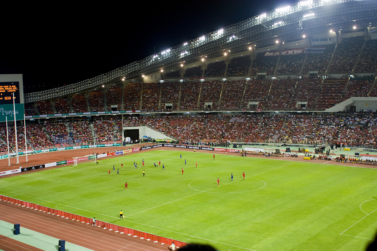 an indoor soccer stadium with a green field