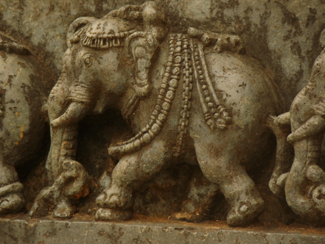 two statues of elephants in front of a wall