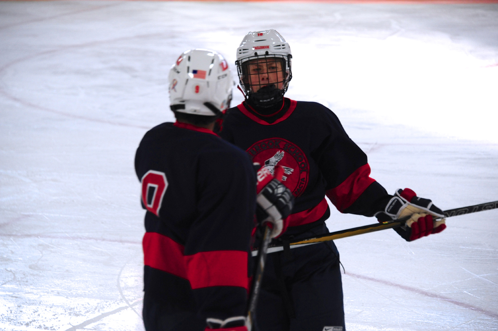 two hockey players on the ice talking to each other