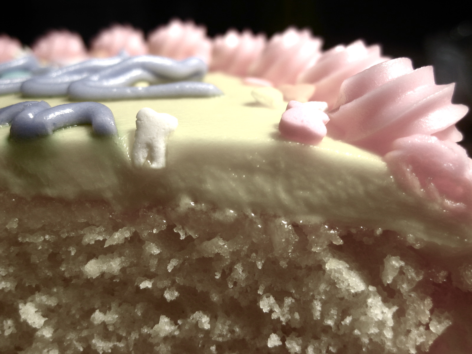 an extreme close up image of a slice of cake with icing
