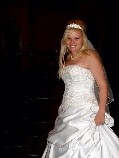 a bride standing in a wedding gown with a veil on her head