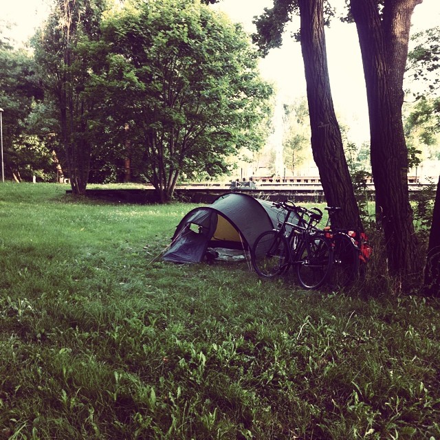 a camping tent and several bicycles are in a park