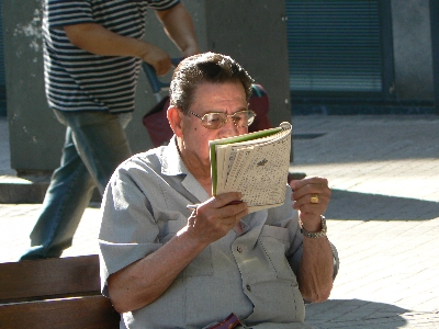 a man sits on a bench and reads a book