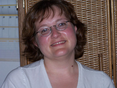a woman wearing glasses is posing for the camera