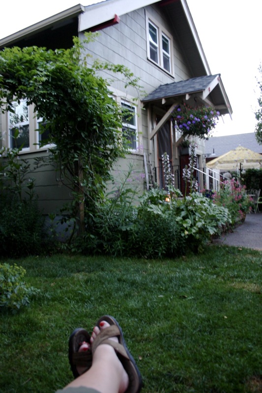 the person is laying on the lawn near a house