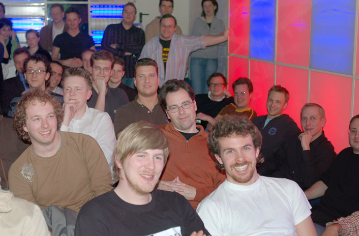 a group of guys sit in front of the television