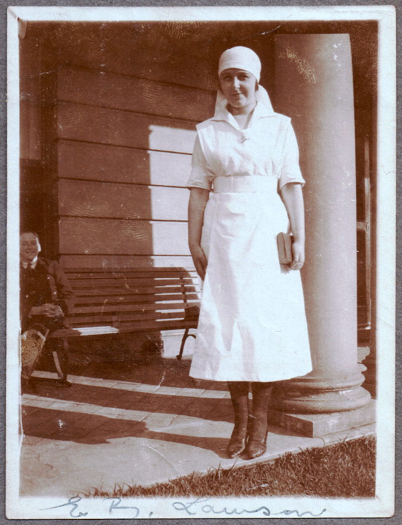 a woman wearing a kitchen apron posing for a po