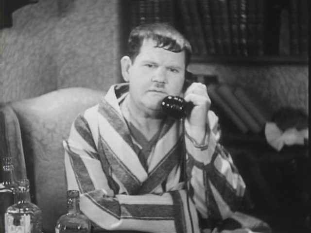 a man is talking on a telephone while drinking alcohol
