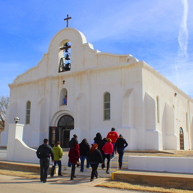 a group of people standing around a church