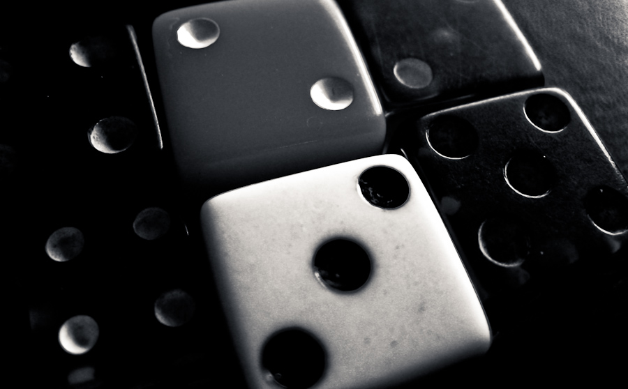 black and white dices on table in dark lighting