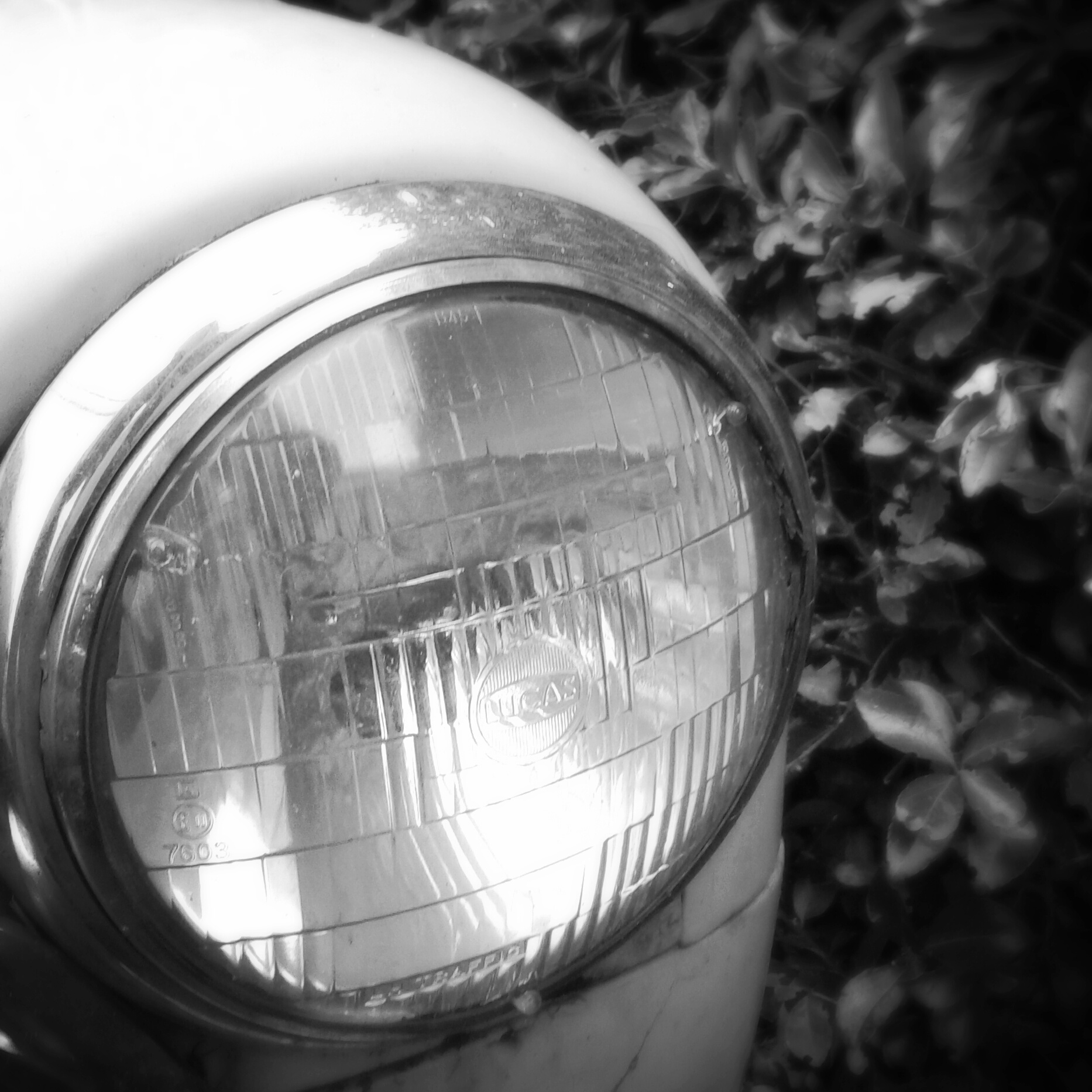 a car headlight on top of a white car