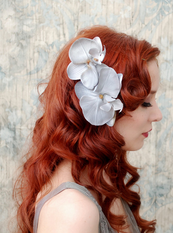 red haired woman with curly hair and flower in her hair