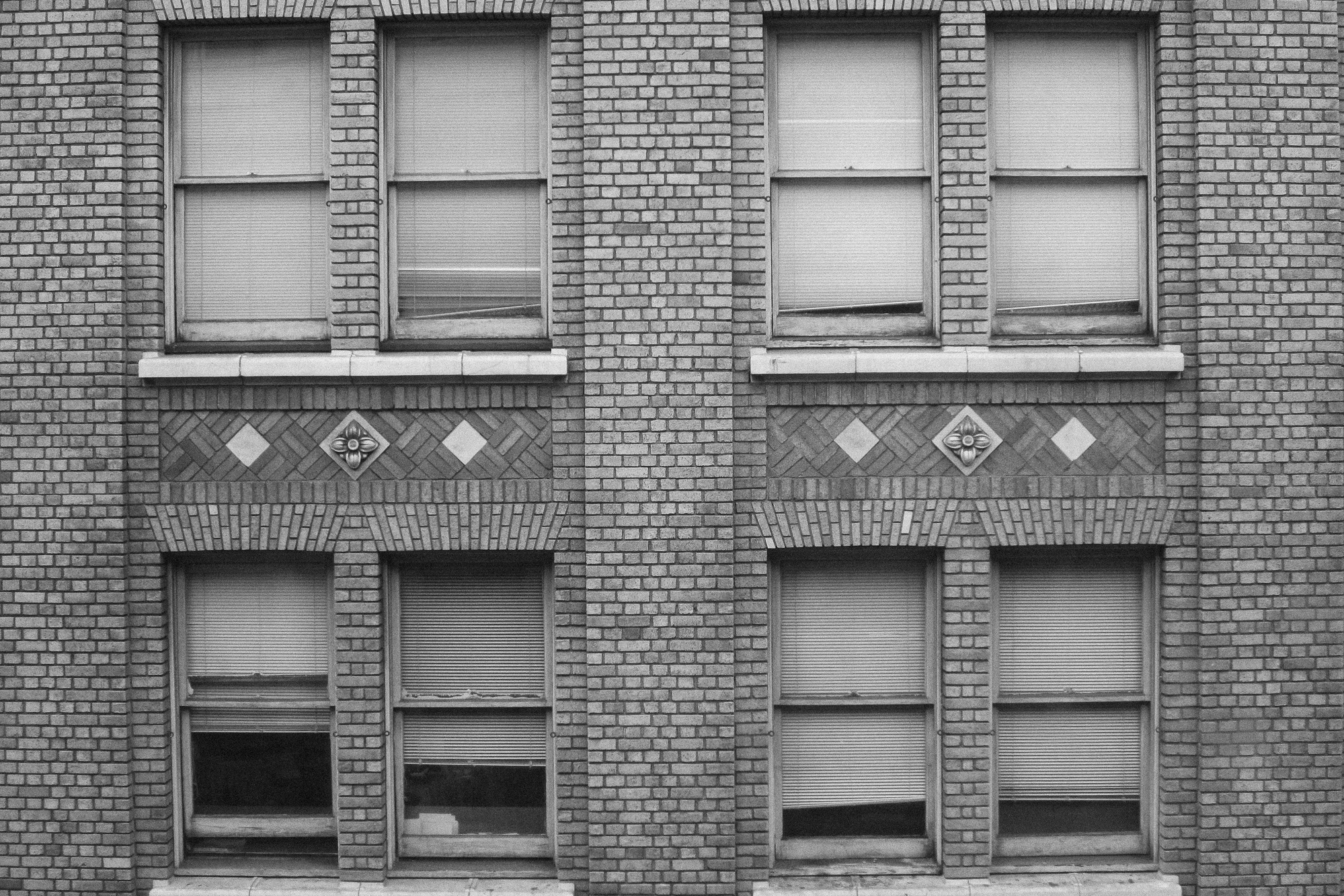 black and white pograph of an old brick building with shutters