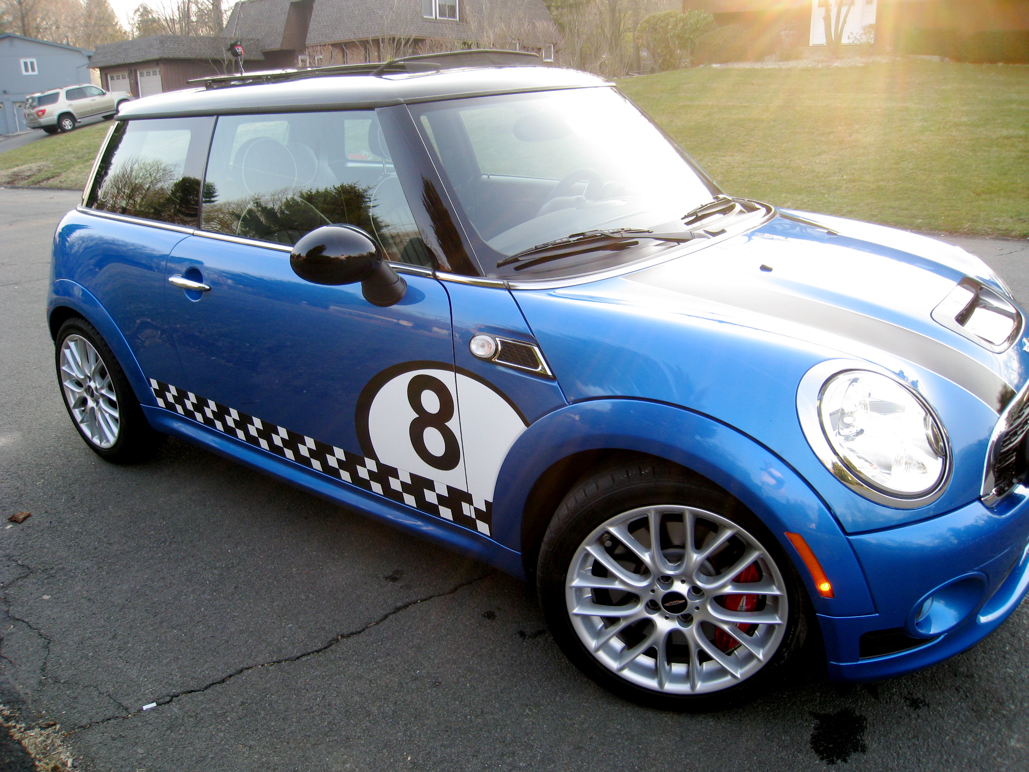 a small blue car is parked in the street