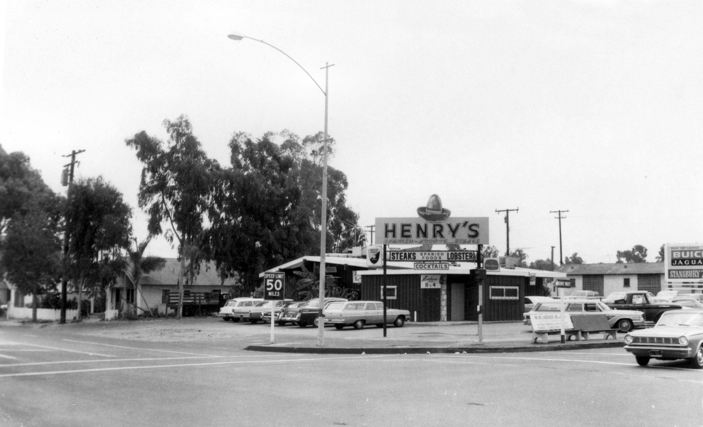 an old black and white po of several vehicles outside