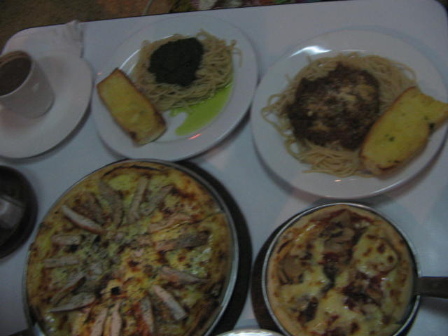 the tray is full of plates of food and two plates with different types of pasta