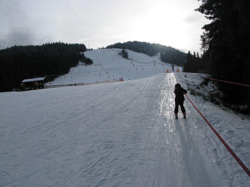 a snow covered ski slope with a person on skis