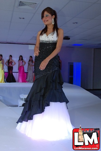 a woman in a long dress standing on a runway