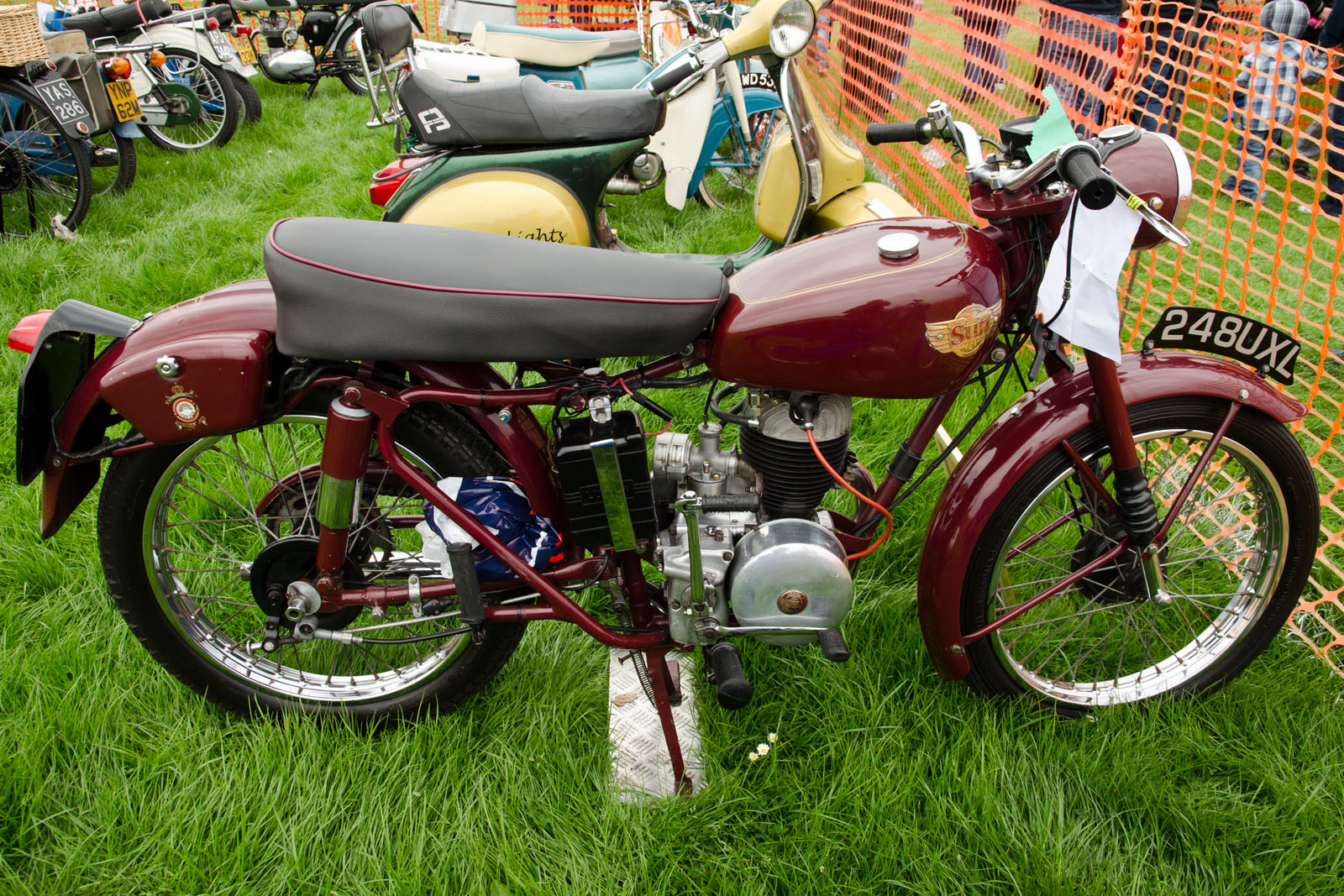 a red motorcycle parked next to many other motorcycles