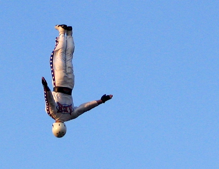 there is a man doing a flip with his feet on a ball