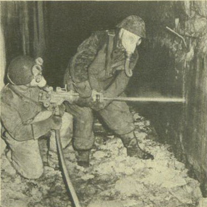 two men wearing uniform are in front of a fire