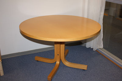 an oval wooden table in front of an open door