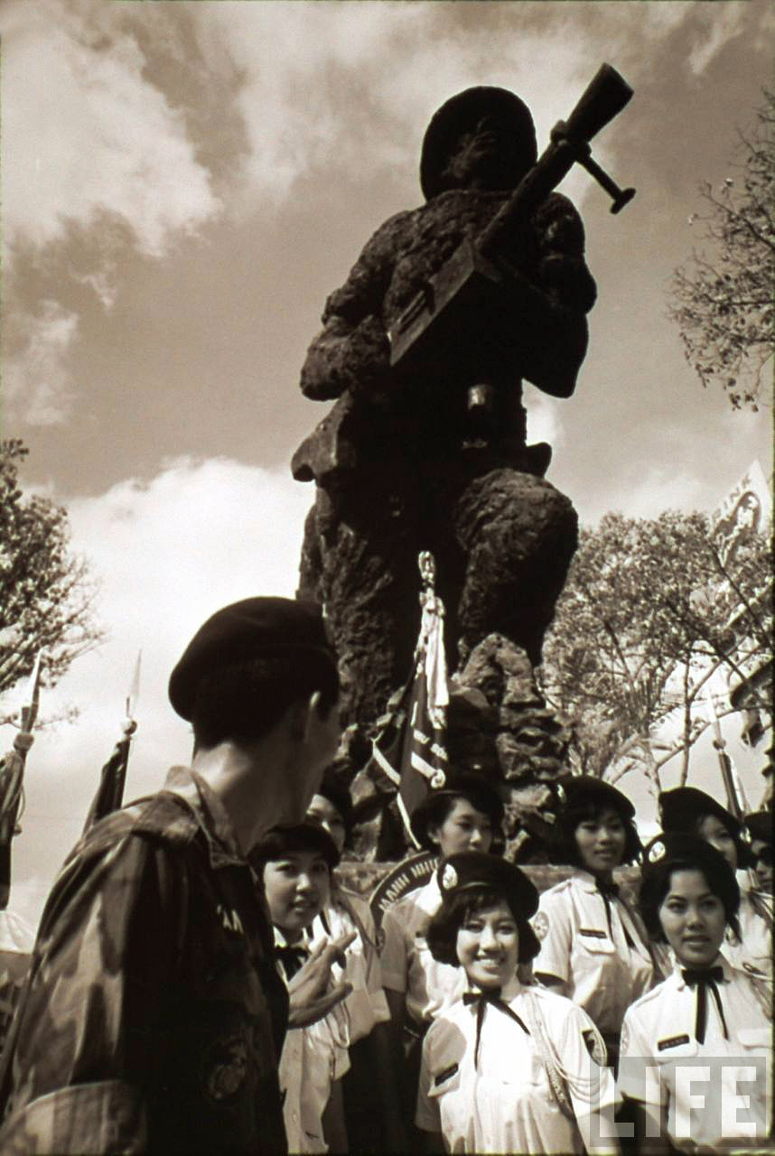 a statue is surrounded by a large group of people