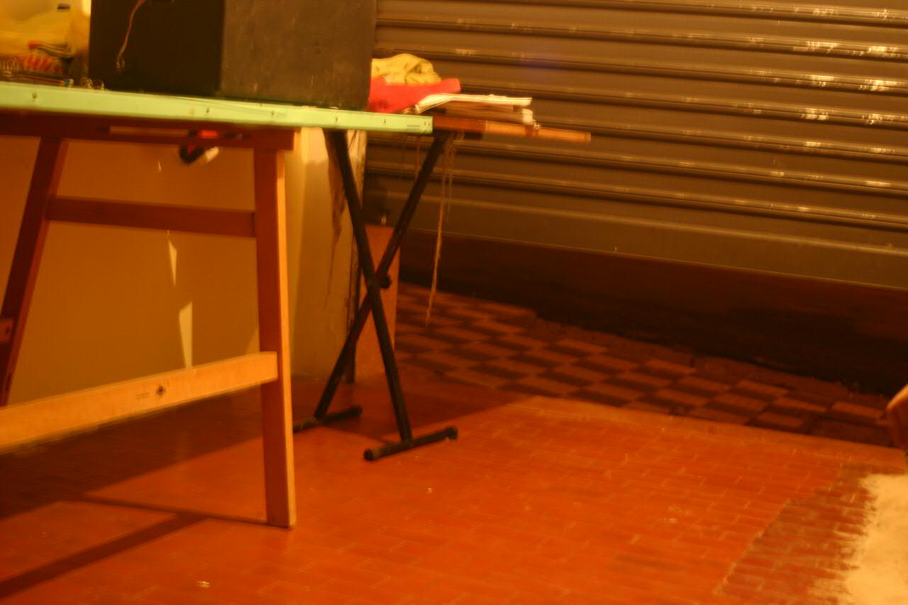 a dog walking on the floor next to a table with many things