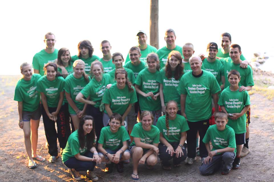 a team of people pose for a picture wearing green t - shirts