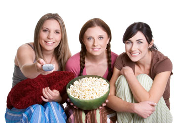 three women stand side by side holding a bowl of popcorn